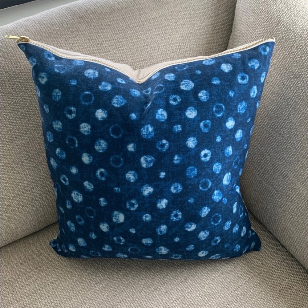 royal blue throw pillow with gold zipper.